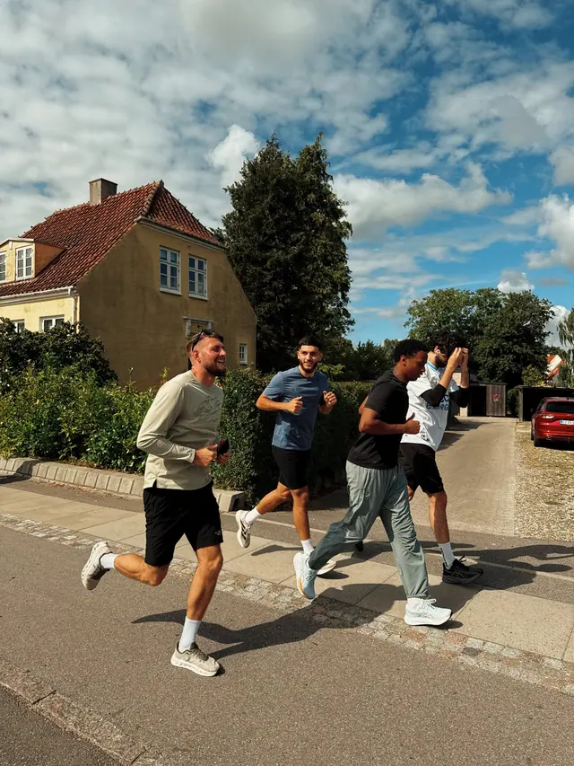 A group running down a sunlit street